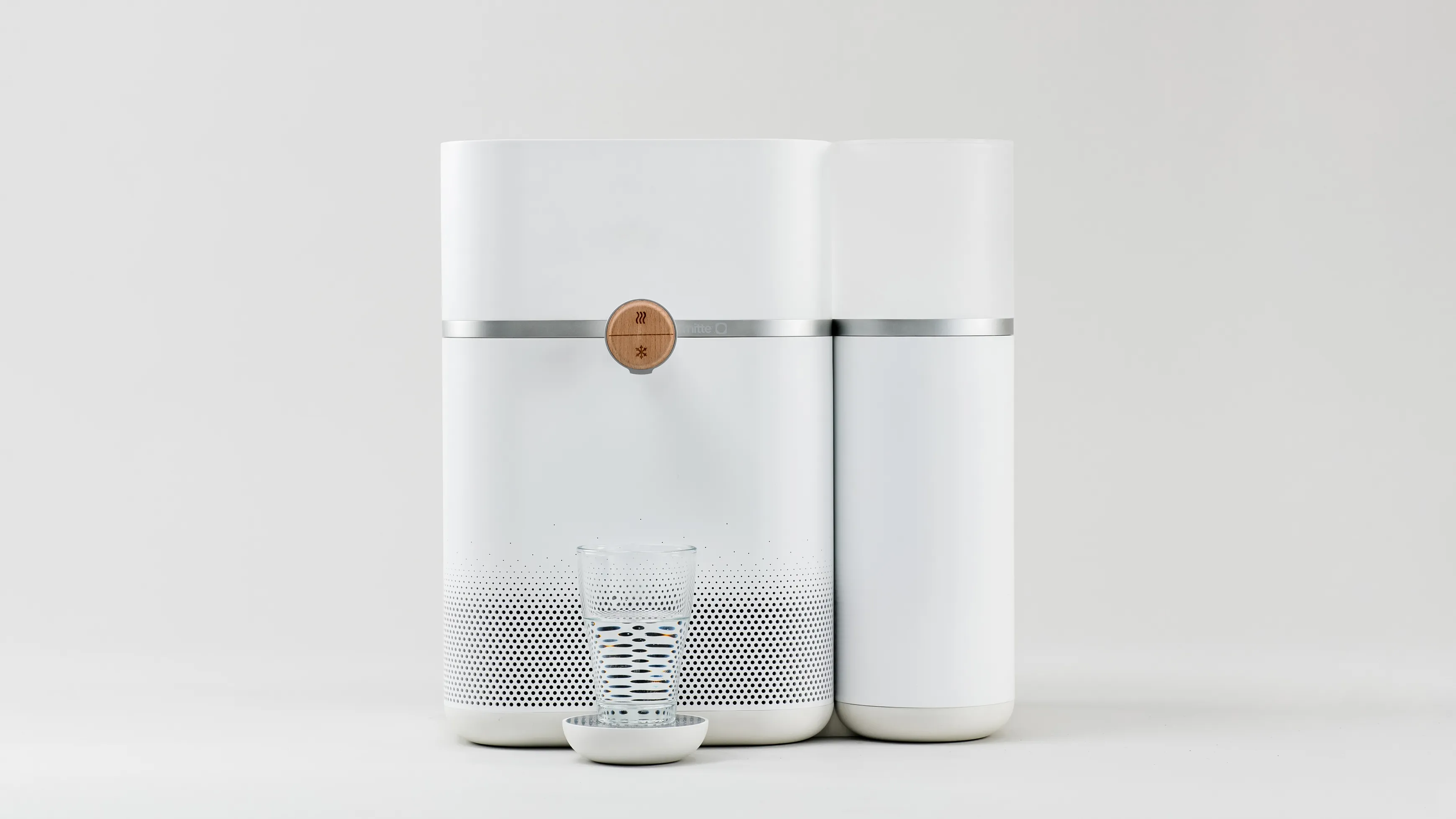 A frontal view of the Mitte water purifier with a water glass