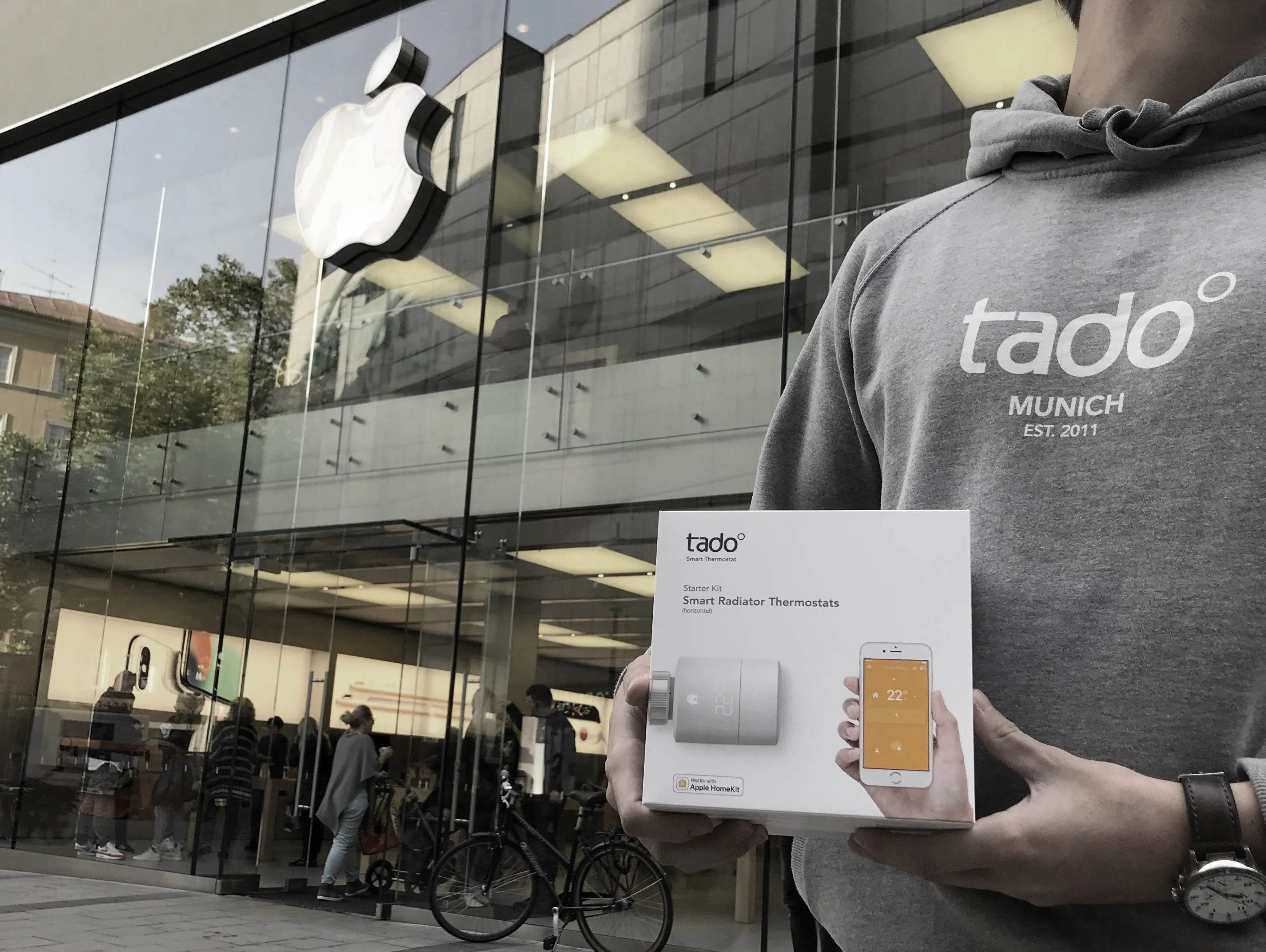 A man holding a tado box in front of an apple store