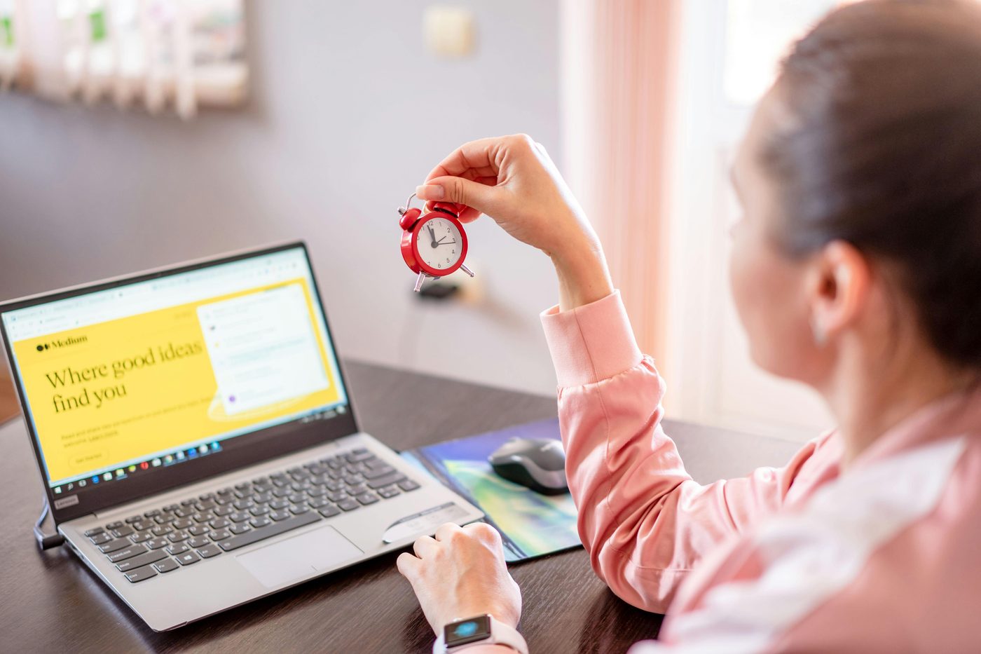 Image showing a person on her laptop while checking the time.