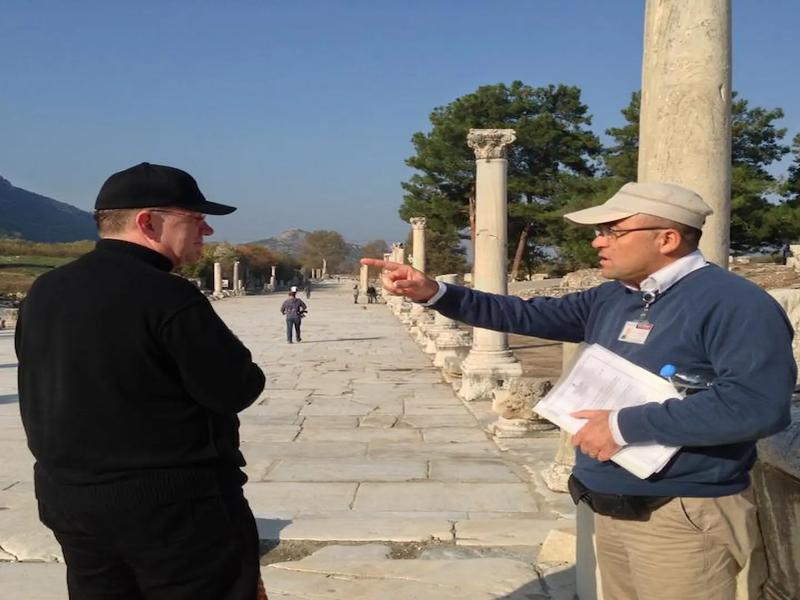 A guide pointing out architectural details on Marble Road in Ephesus to a private guest