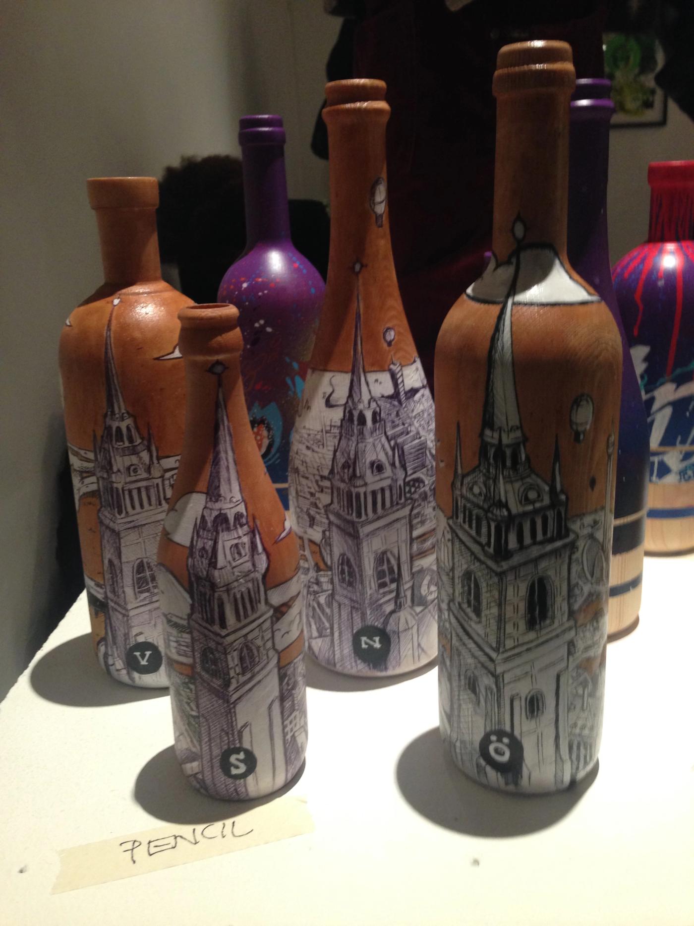 Fyra handmålade träflaskor som visar norr, öster, söder och väster om Gamla stan i Stockholm. Four hand-painted wooden bottles showing north, east, south and west of Stockholm from Gamla stan.