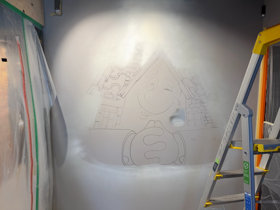 Blyertsskiss av Lebe-maskoten på kontorsväggen innan målningen, med stege och plastskydd. Pencil sketch of the Lebe mascot on the office wall before painting, with a ladder and plastic protection.