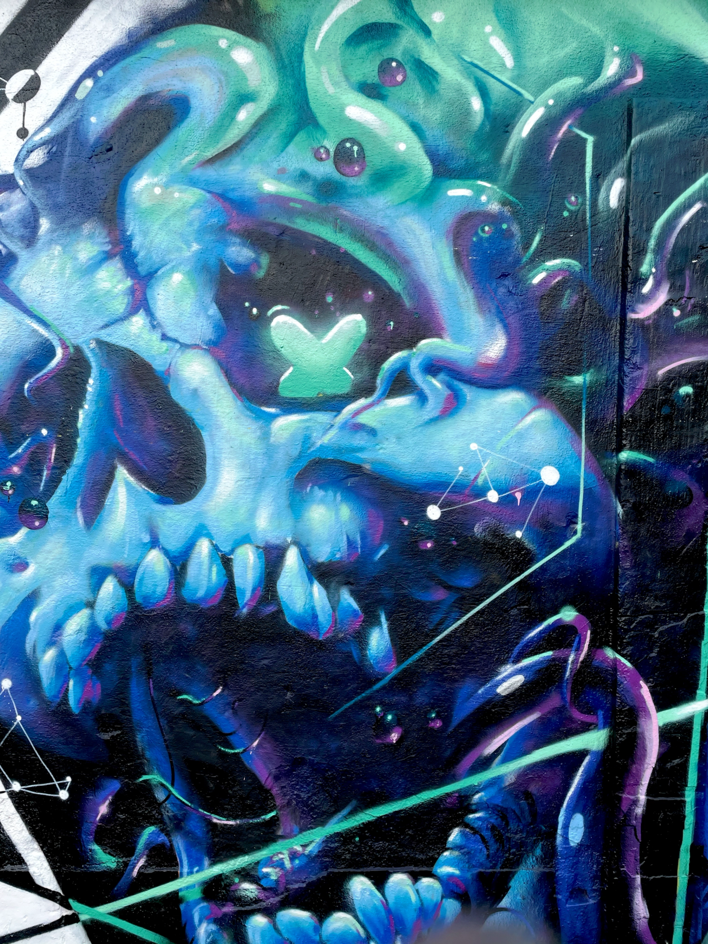 Närbild på den lysande blå dödskallen med tentakler på A.Fisher-målningen i Snösätra. Close-up of the glowing blue skull with tentacles on the A.Fisher mural in Snösätra.