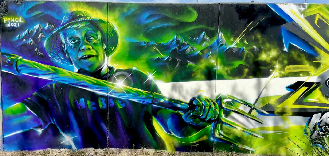 En bonde stormar fram med högaffel i slutstriden i The Raukonium Saga, offentlig väggmålning i Visby på Gotland. Farmer charging with a pitchfork in the final battle of The Raukonium Saga, a public mural in Visby, Gotland.