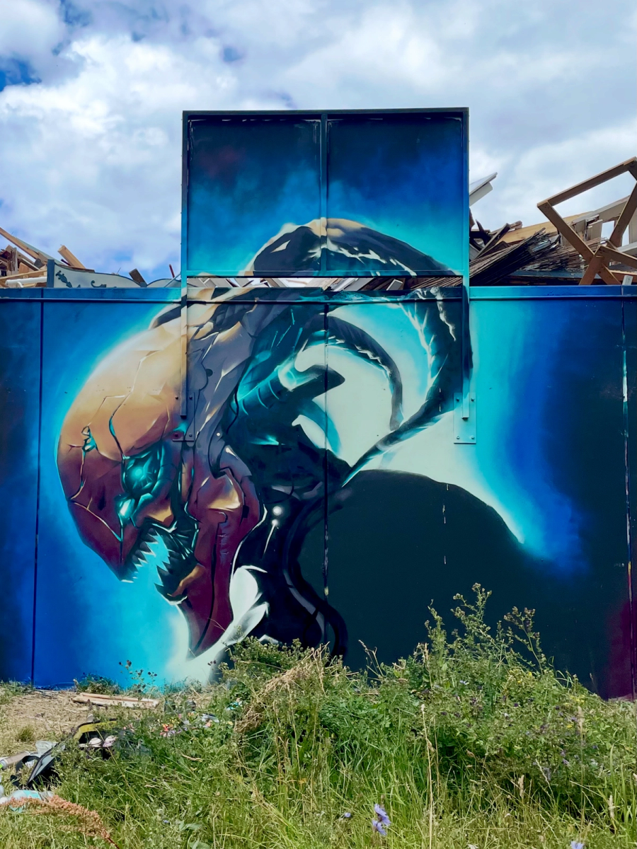 Pågående arbete med varelserna i Raukonium-målningen i Visby, där den mörka figuren ännu inte är färdig. Work in progress on the alien creature section of The Raukonium Saga mural in Visby, with the dark figure still unfinished.