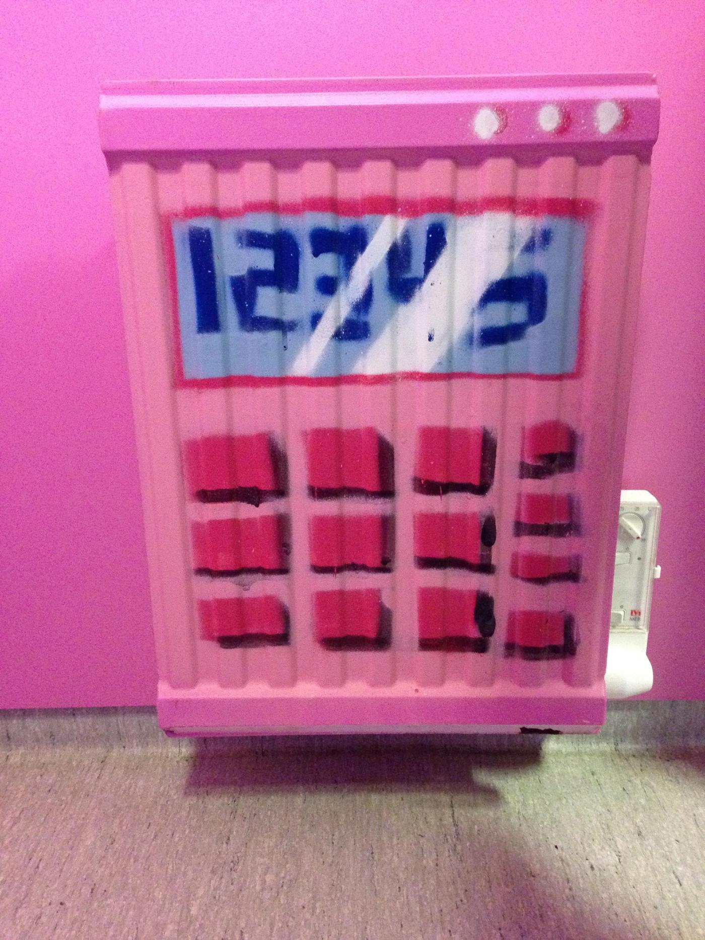 Element på Vibyskolan målat som en rosa miniräknare med siffrorna 12345 på displayen. Radiator at Vibyskolan painted as a pink calculator with the numbers 12345 on its display.