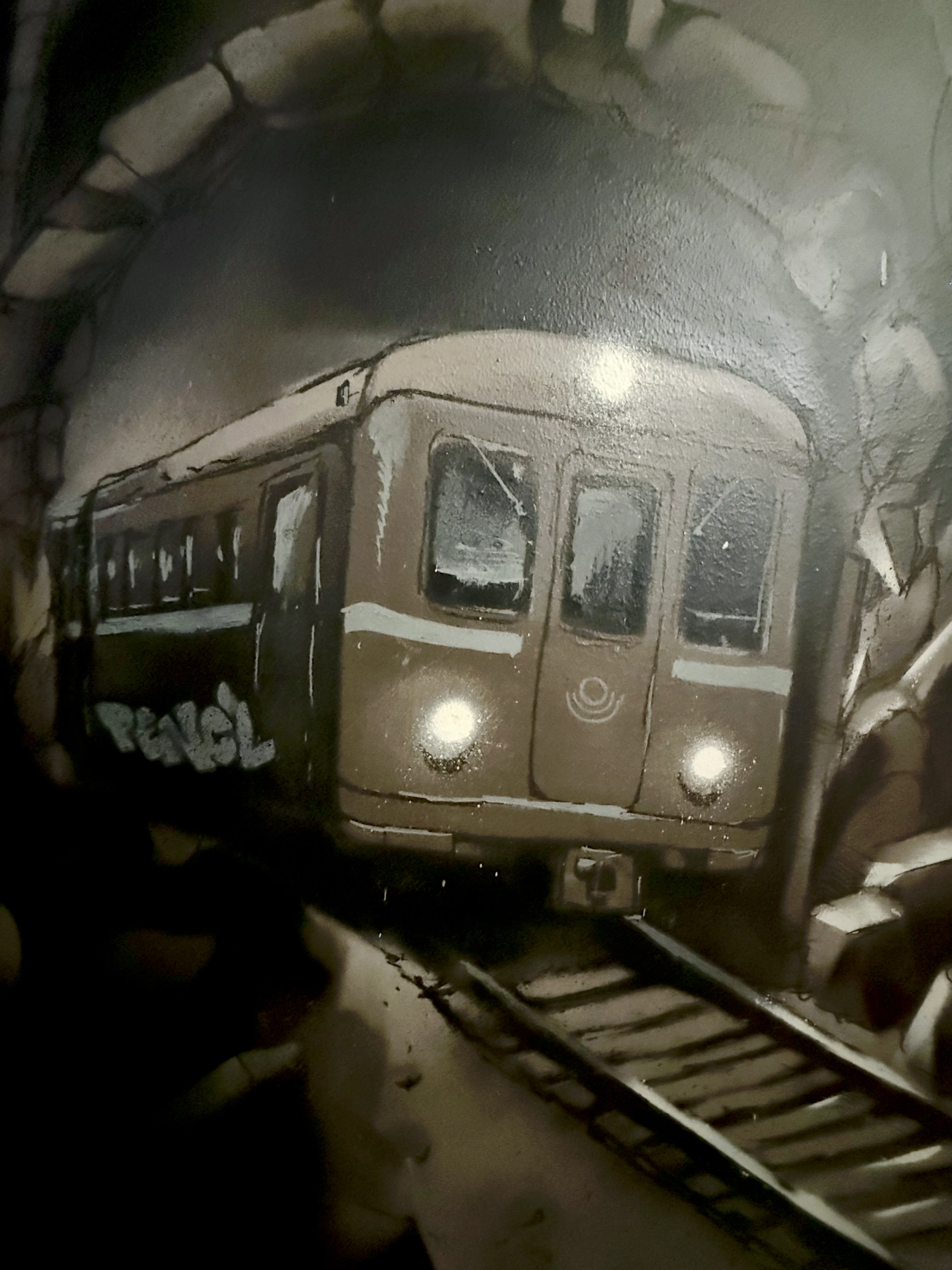 Gammalt tunnelbanetåg i Stockholm som kommer ut ur en tunnel, med konstnärens tagg Pencil på sidan. Vintage Stockholm subway train coming out of a tunnel, with the artist's Pencil tag on its side.
