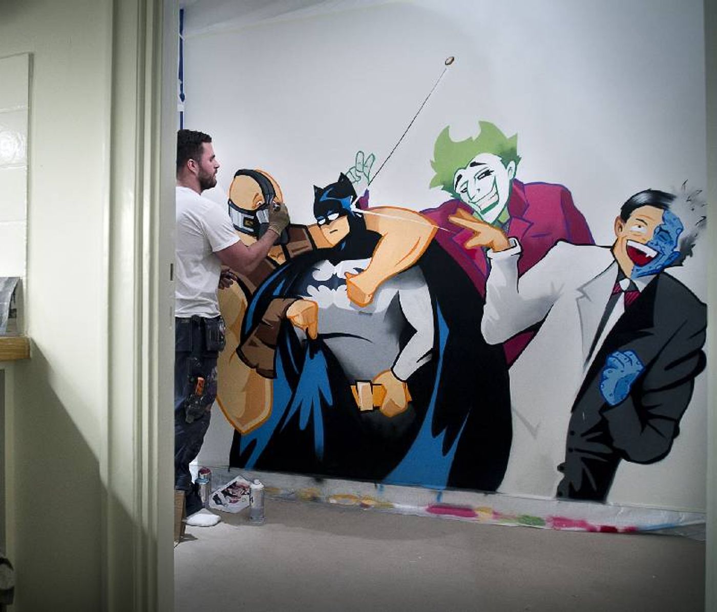 Konstnären målar Batmanskurkarna i ett hem i Enskede. The artist painting the Batman villains mural in a home in Enskede.