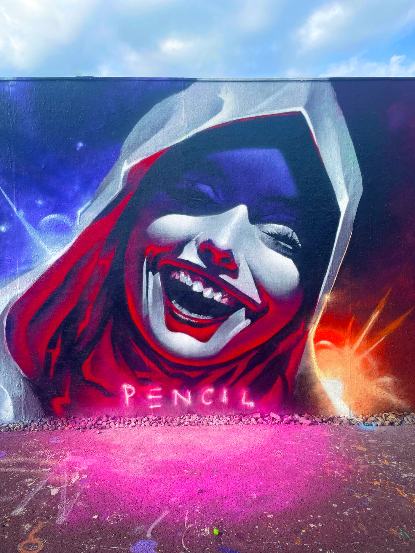 Graffitimålning av en skrattande nunna i röd huva mot en stjärnhimmel i Snösätra, med konstnärsnamnet Pencil under. Graffiti mural of a laughing nun in a red hood against a starry sky in Snösätra, with the artist name Pencil below.