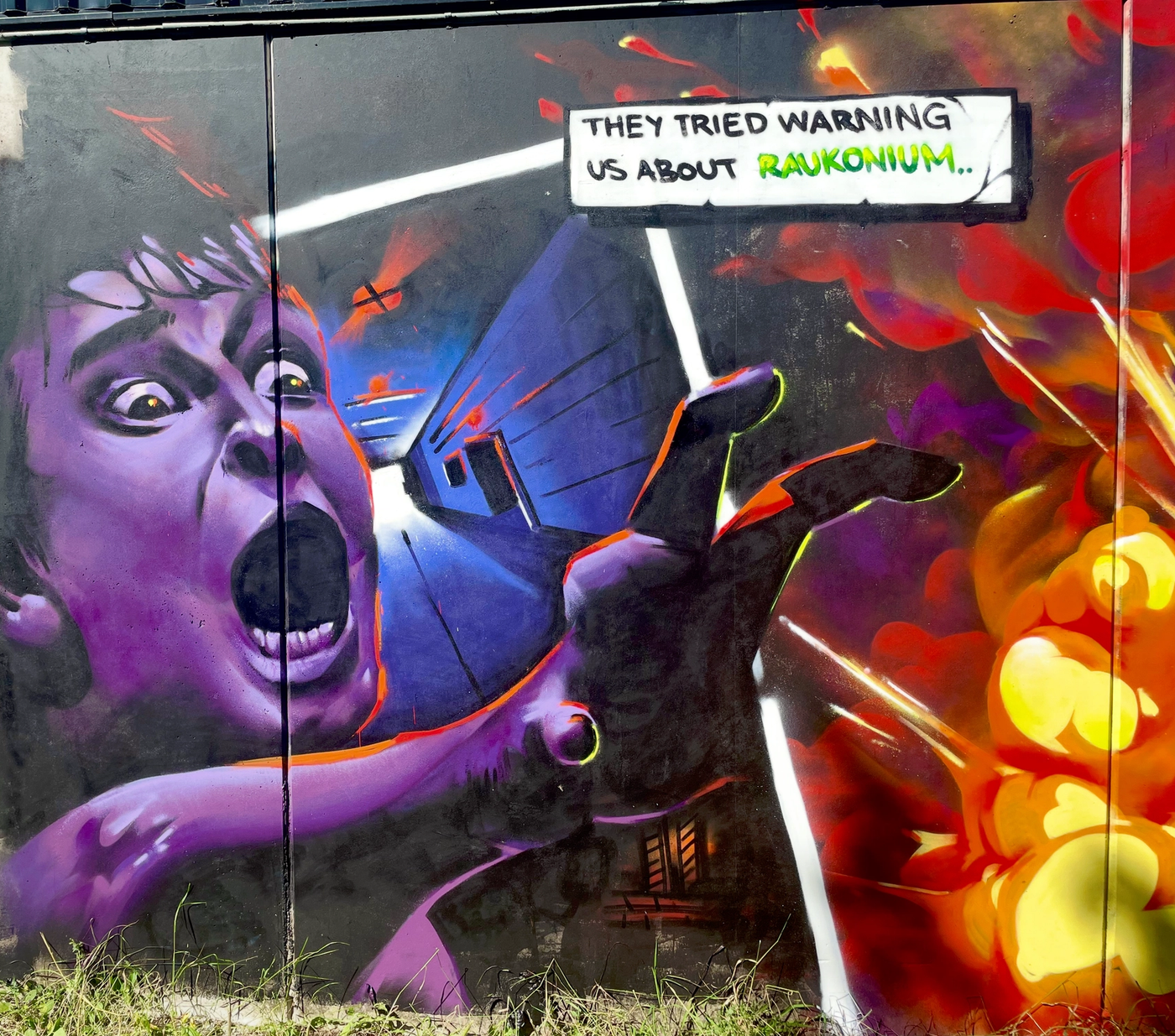 Den skrikande pojken och explosionerna ur kapitel 7 av The Raukonium Saga, en offentlig väggmålning i Visby. Wide view of the screaming boy and explosion scene from chapter 7 of The Raukonium Saga, a public mural in Visby, Gotland.
