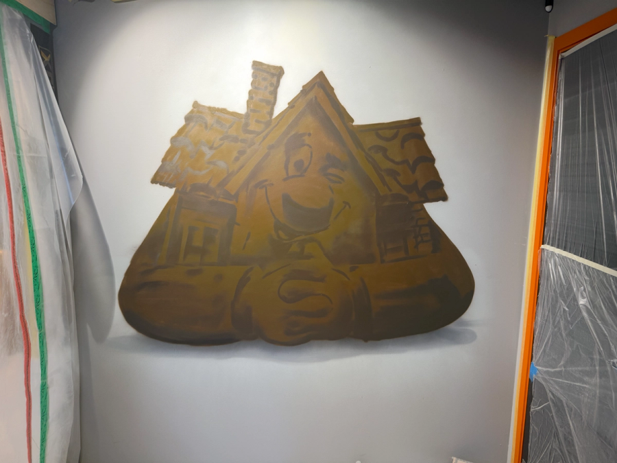 Grundlagret till den gyllene Lebe-maskoten i bruna och bronsfärgade toner, under arbete. Base layer of the golden Lebe mascot mural in brown and bronze tones, work in progress.