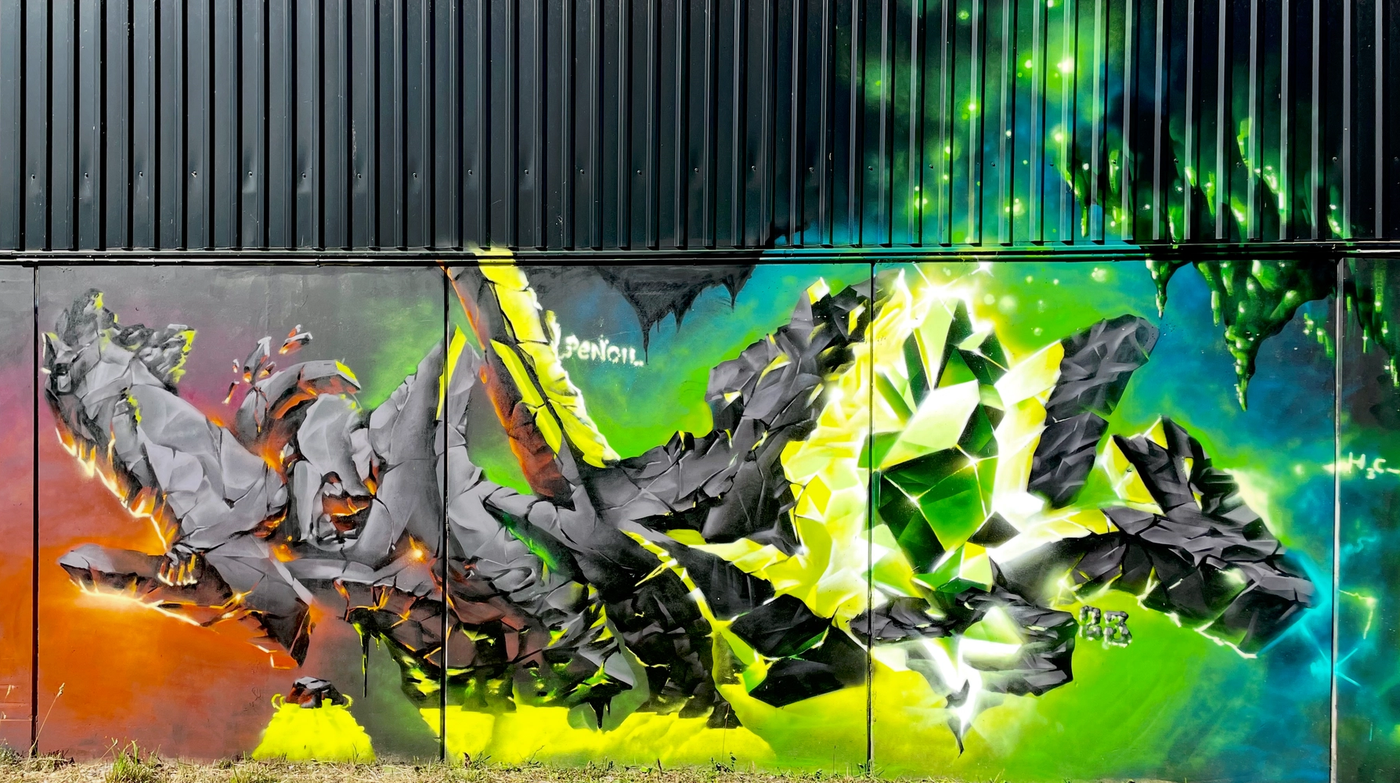 Graffitibokstäver av sten med ett starkt grönt kristallsken, kapitel 6 av The Raukonium Saga i Visby. Rock graffiti letters with a bright green crystal glow, chapter 6 of The Raukonium Saga public mural in Visby, Gotland.
