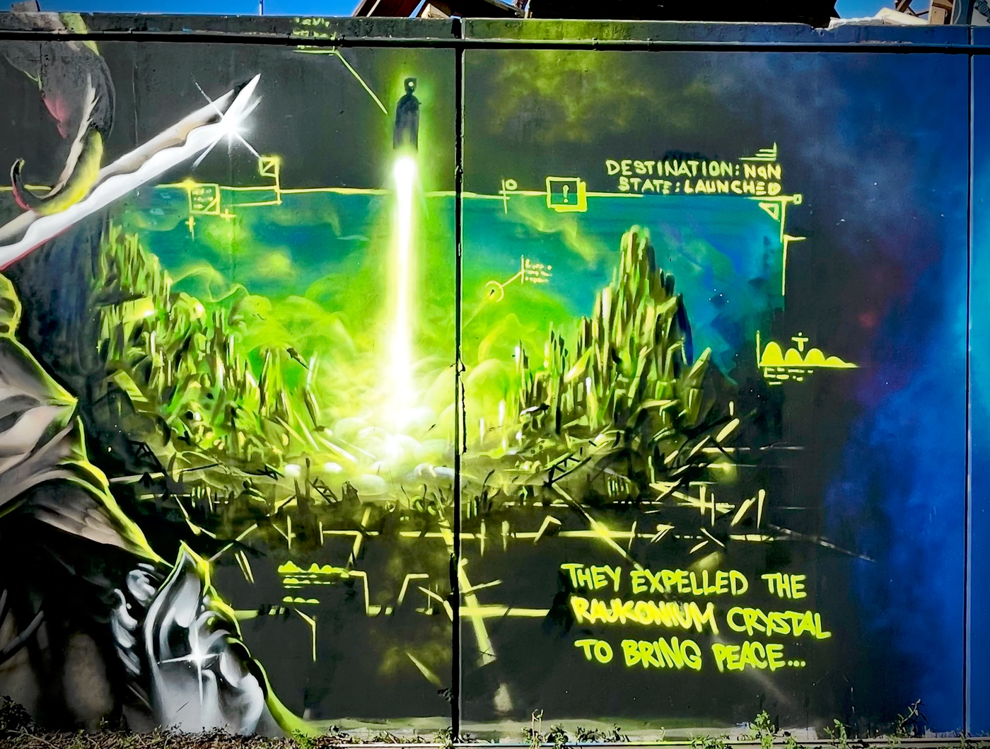 Spraymålad scen där en lysande grön Raukonium-kristall skjuts ut i rymden, med texten They expelled the Raukonium crystal to bring peace. Spray-painted scene of a glowing green Raukonium crystal launched into space, with the text They expelled the Raukonium crystal to bring peace.