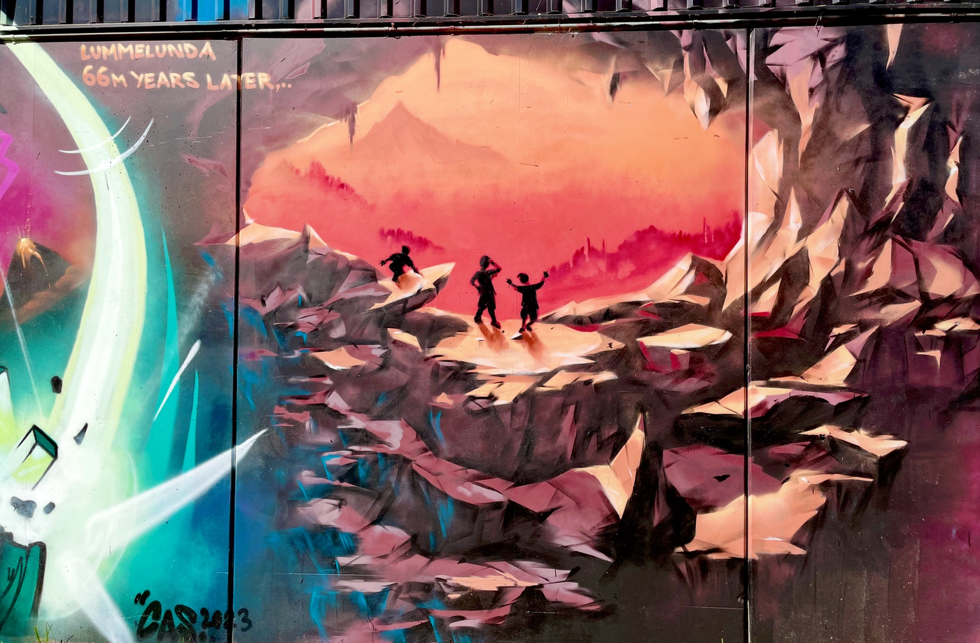 Tre pojkar i siluett i ett rött grottlandskap, upptäckten av Lummelundagrottan i Raukonium-målningen i Visby. Three boys silhouetted in a red cave landscape, the discovery of the Lummelunda caves in The Raukonium Saga mural in Visby.