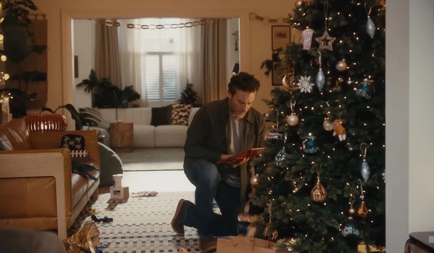 A dad kneeling by a Christmas tree in John Lewis’ emotional advertising campaign