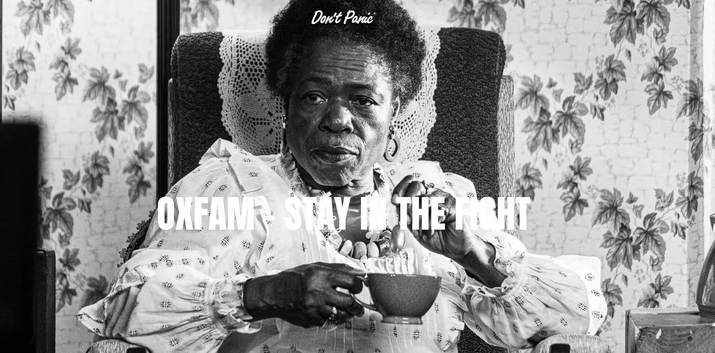 An older woman looking at the camera stoically and drinking tea in Oxfam’s emotional advertising campaign