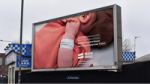 A powerful billboard from the Health Equals campaign displayed in Glasgow, featuring a poignant image of a newborn baby, highlighting successful hybrid marketing examples.