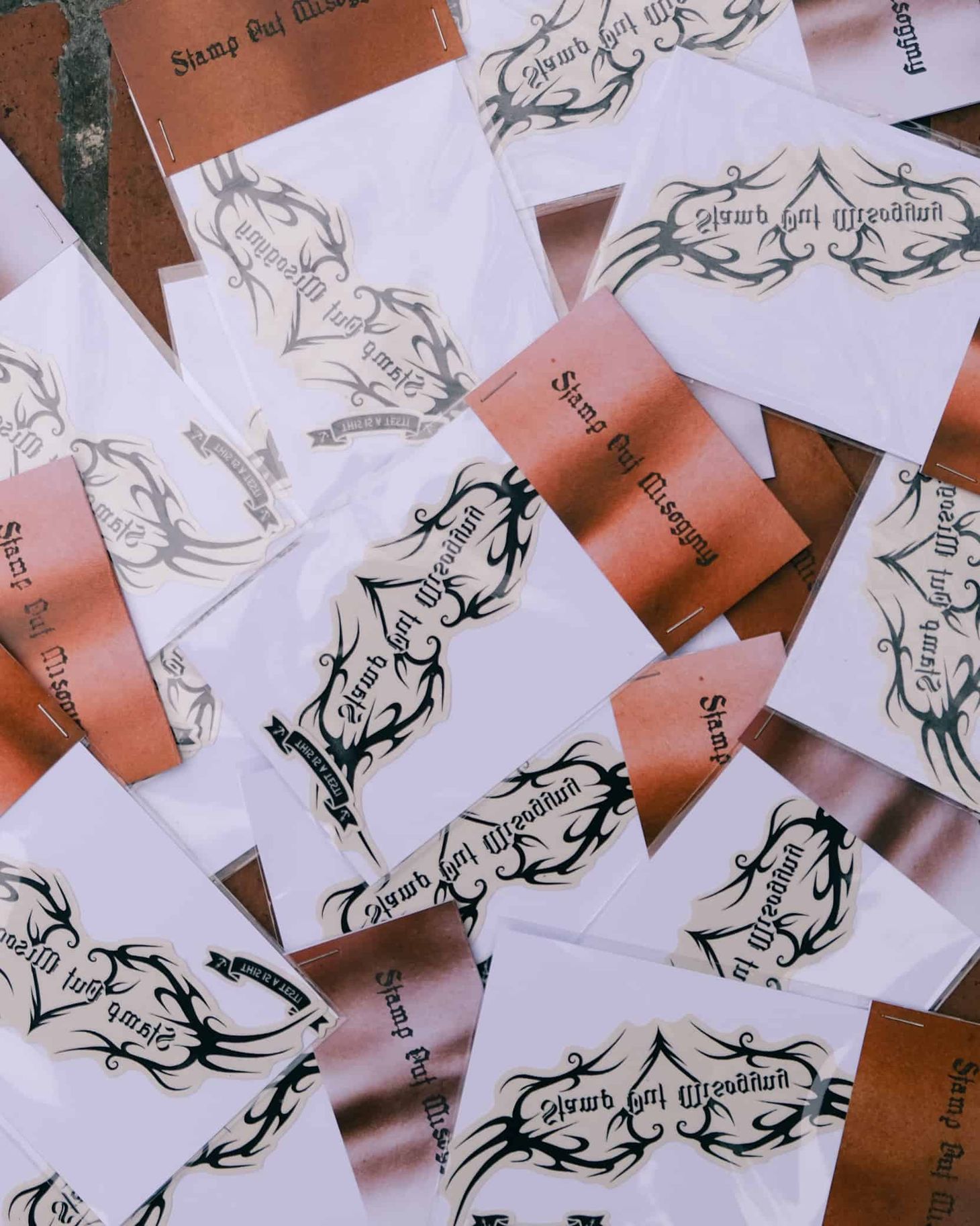 Pile of temporary transfer tattoos that read 'Stamp Out Misogyny'