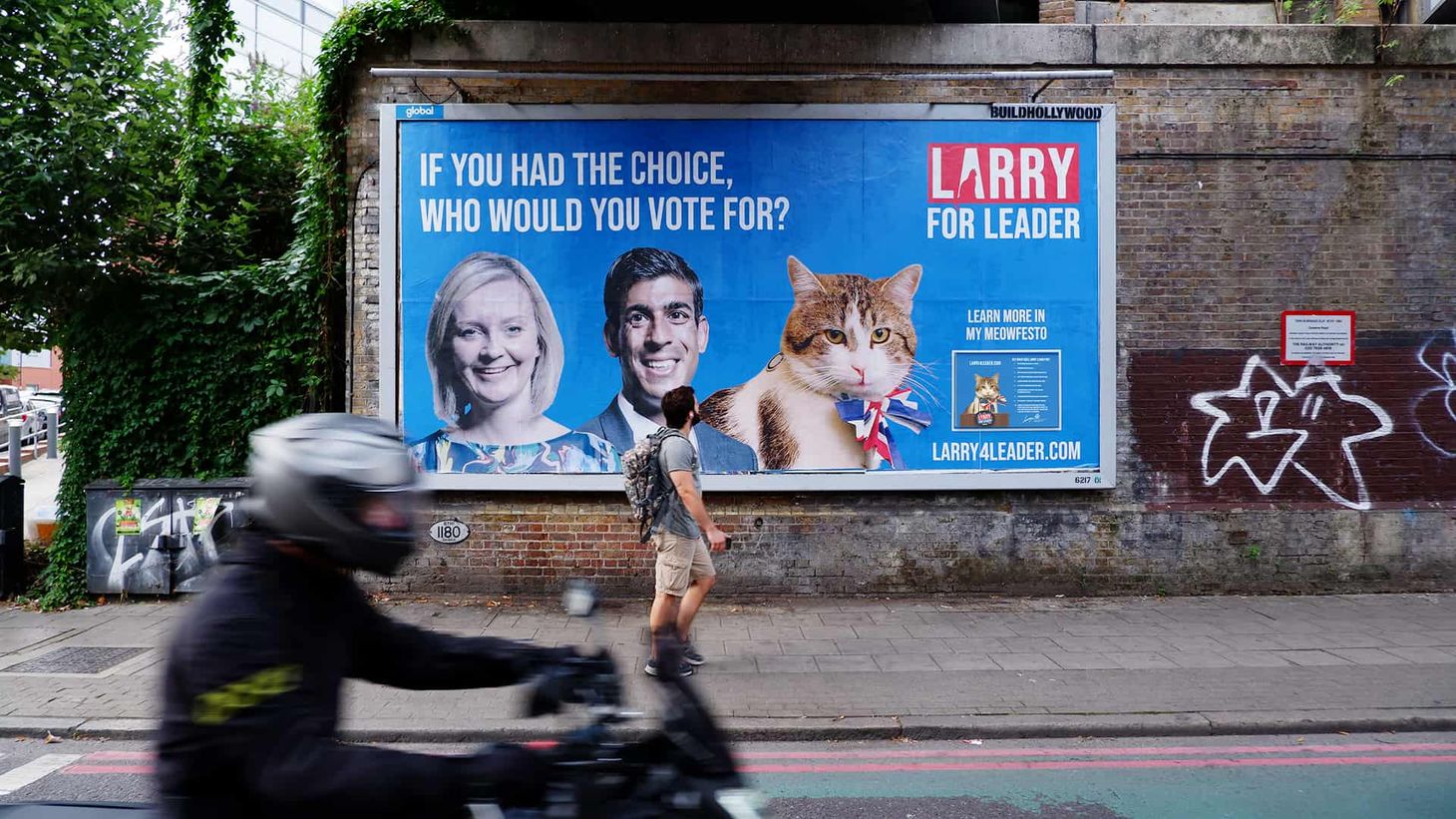 Larry 4 Leader campaign billboard on the path with man looking at it as he walks past