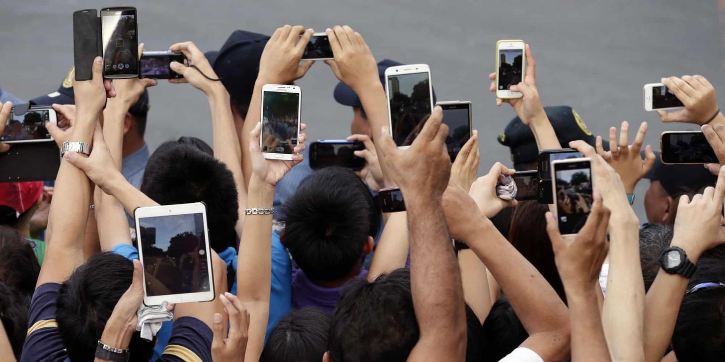 people taking photos with their smartphones millennials