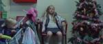 Still from Don't Panic London's Good as Gold film for Shelter: a young girl in a silver coat waits on a red chair beside a Christmas tree