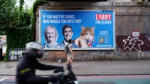 A large “Larry for Leader” billboard shows Larry the Cat alongside political figures, photographed on a London street for Don’t Panic London’s viral campaign.