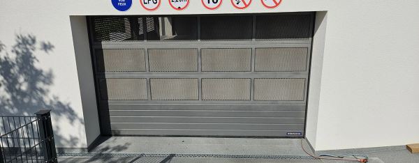 Aluminium-Sektionaltor einer Tiefgarage mit Streckmetallfüllung, Hörmann, Verkehrsschilder