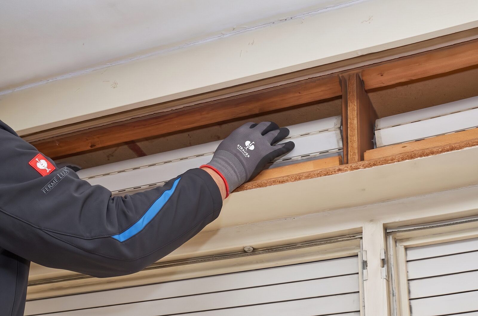 Fermé-Lux technician refitting the slats of a roller shutter curtain inside its open box