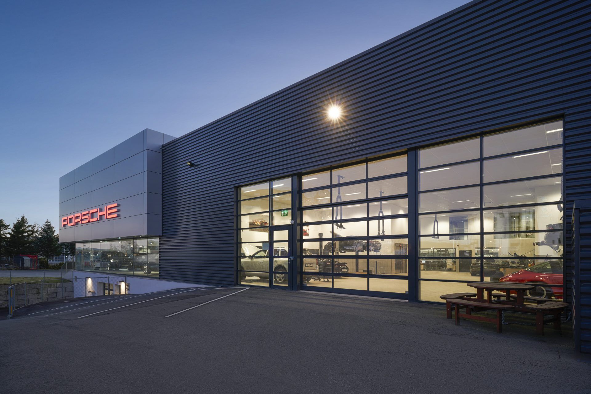 Verglaste Hörmann-Industrie-Sektionaltore ALR F42 an der Fassade eines Autohauses, abends beleuchtet