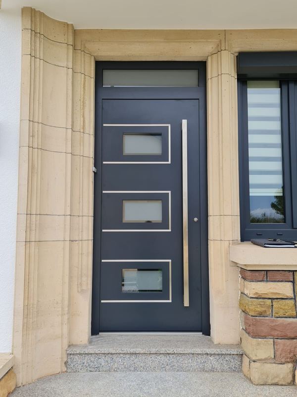 Anthrazit Haustür mit drei satinierten Glasfeldern in Edelstahlrahmen, Oberlicht und Sandsteingewände