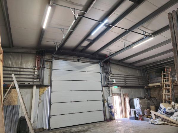 Weißes Industrie-Sektionaltor in einer Halle mit Stahlkonstruktion, Innenansicht