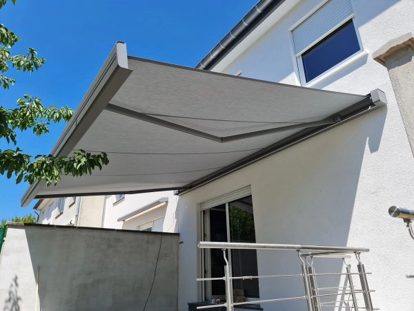 Hellgraue Kassettenmarkise am weißen Haus mit Edelstahlgeländer, Untersicht