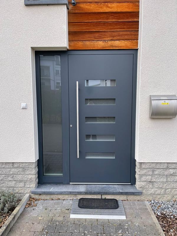 Anthrazit Haustür mit fünf satinierten Glasstreifen, hohem Seitenteil und Stangengriff, Holzverkleidung darüber