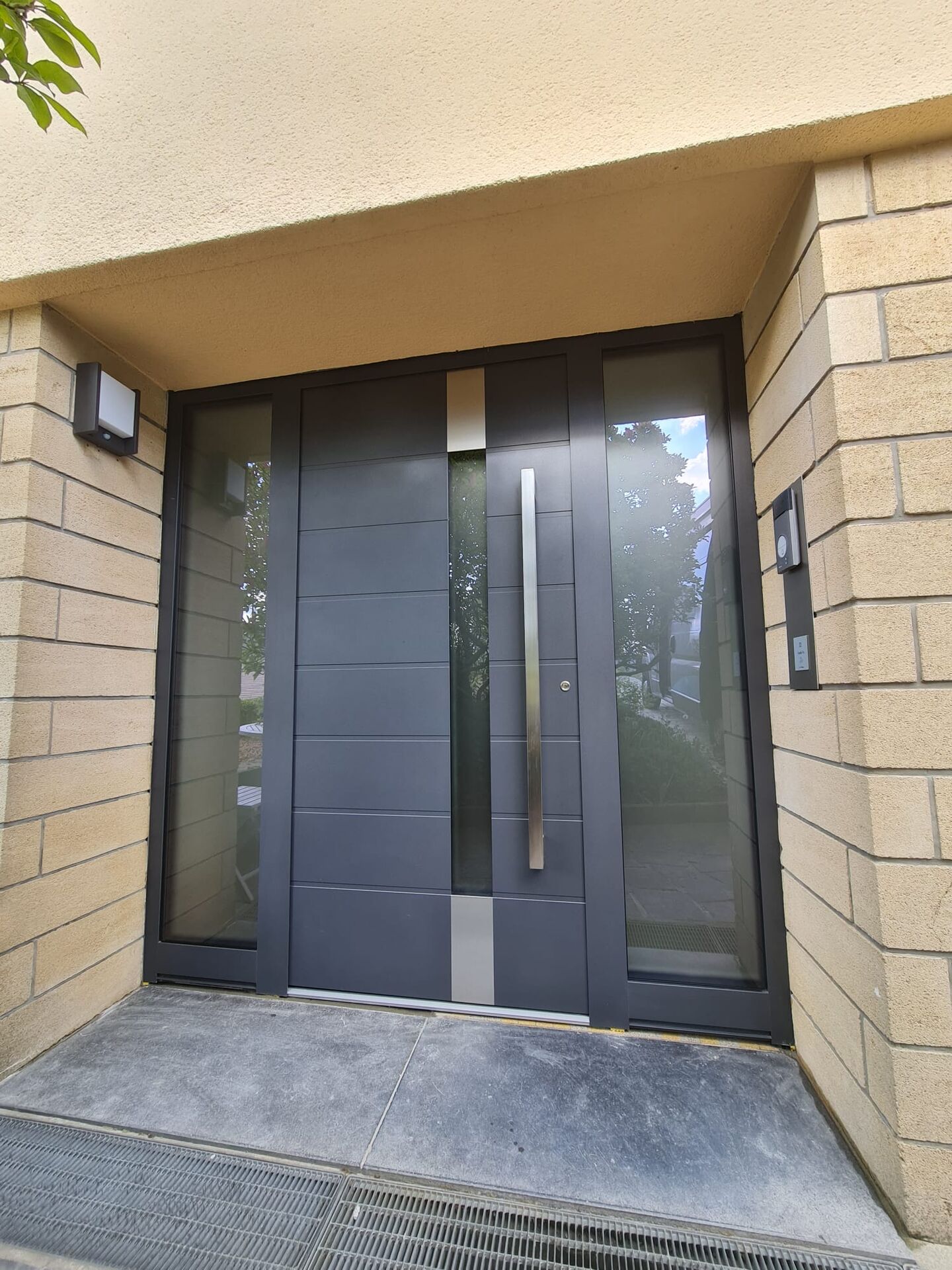 Anthrazitfarbene Haustür mit Rillen, Glasstreifen, Edelstahl-Stangengriff und zwei verglasten Seitenteilen