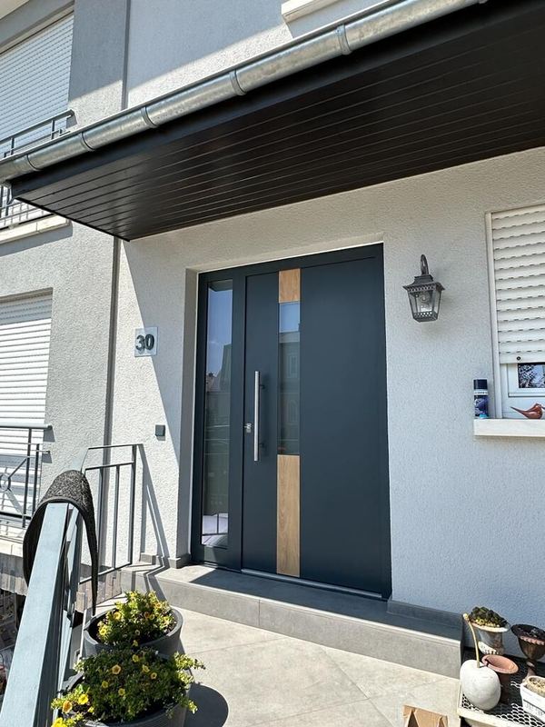 Anthrazit Haustür mit Holzdekor-Streifen und Glasstreifen, Seitenteil, unter dunklem Dachüberstand