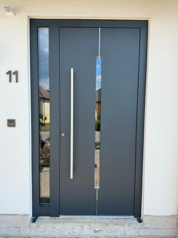 Anthrazit Haustür mit schmalem senkrechtem Glasschlitz, Edelstahllinie, Seitenteil und Stangengriff