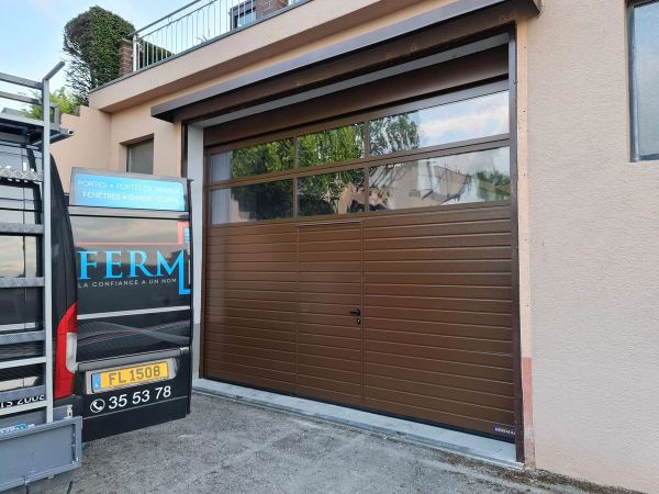 Braunes Sektionaltor in Holzoptik mit Schlupftür und verglasten oberen Reihen