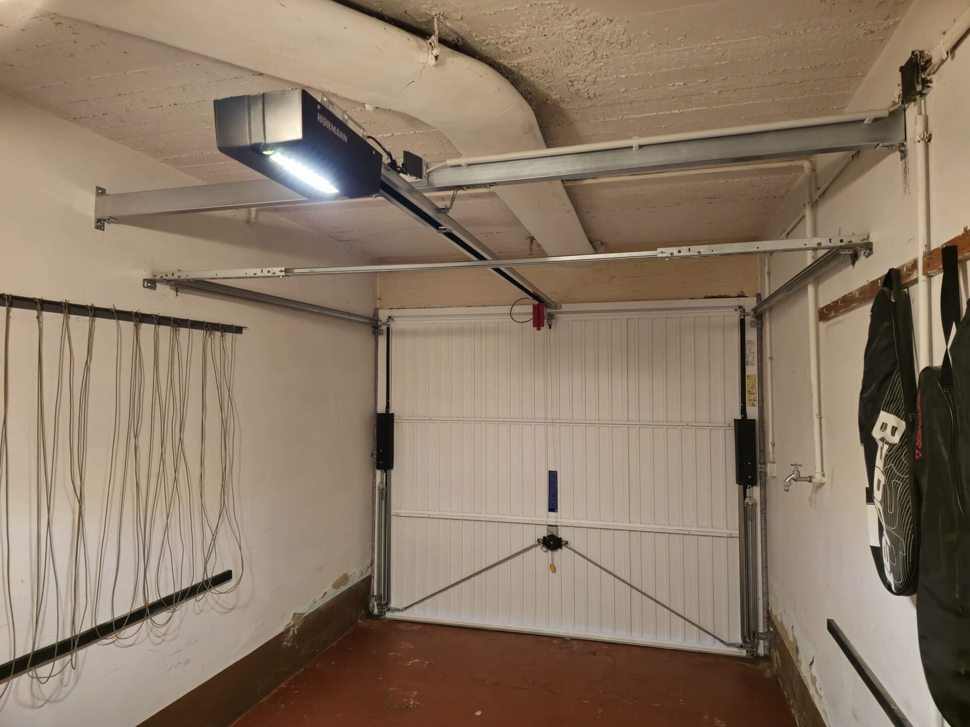 White up-and-over garage door seen from inside, fitted with a ceiling rail opener