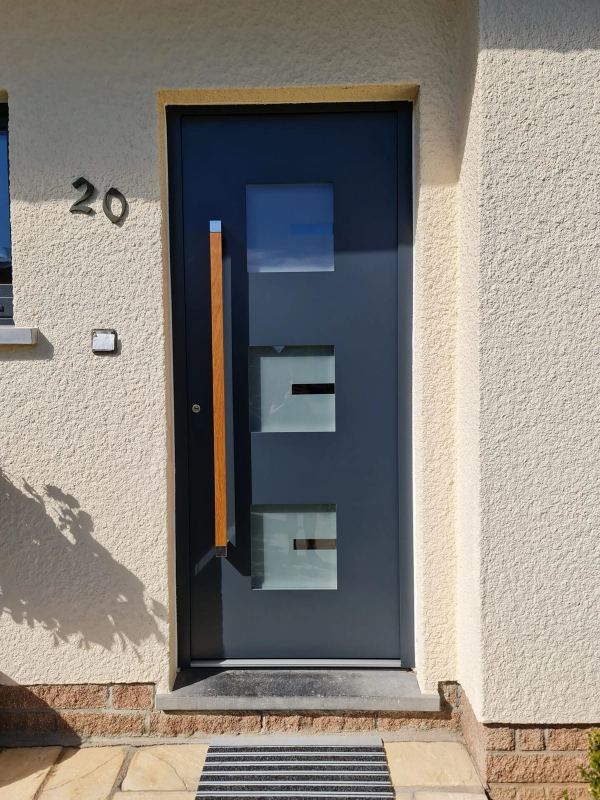 Anthrazit Haustür mit drei Glasfeldern und Stangengriff in Holzoptik an beiger Putzfassade