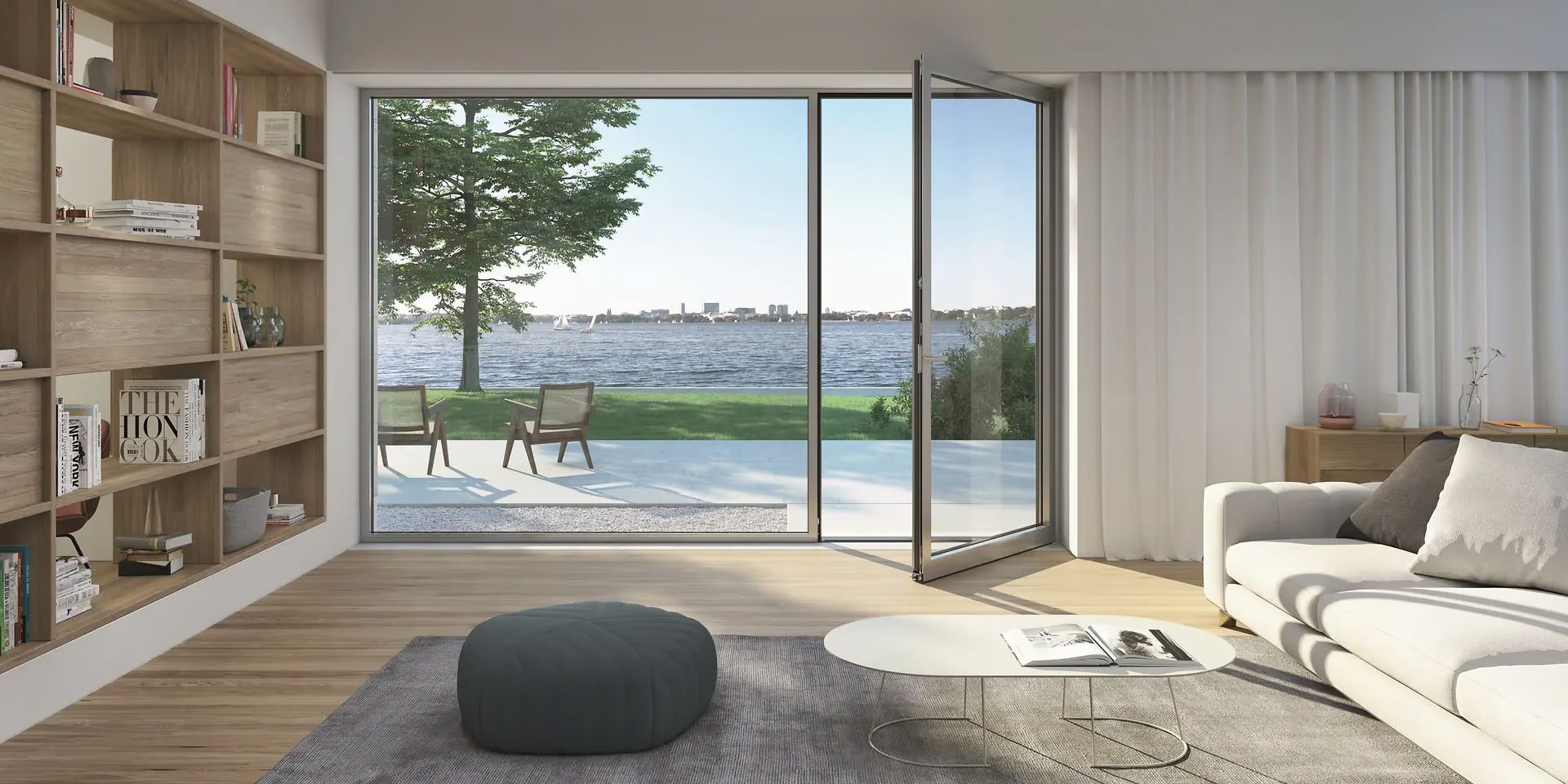 Helles Wohnzimmer mit großer, schmal profilierter Fenstertür, die sich zu einer Terrasse am See öffnet
