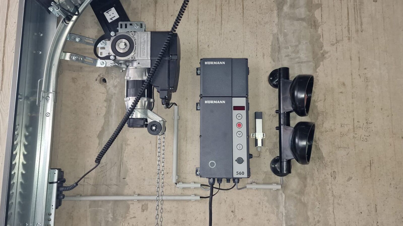 Industrial door operator and Hörmann control unit mounted on the wall beside the door track