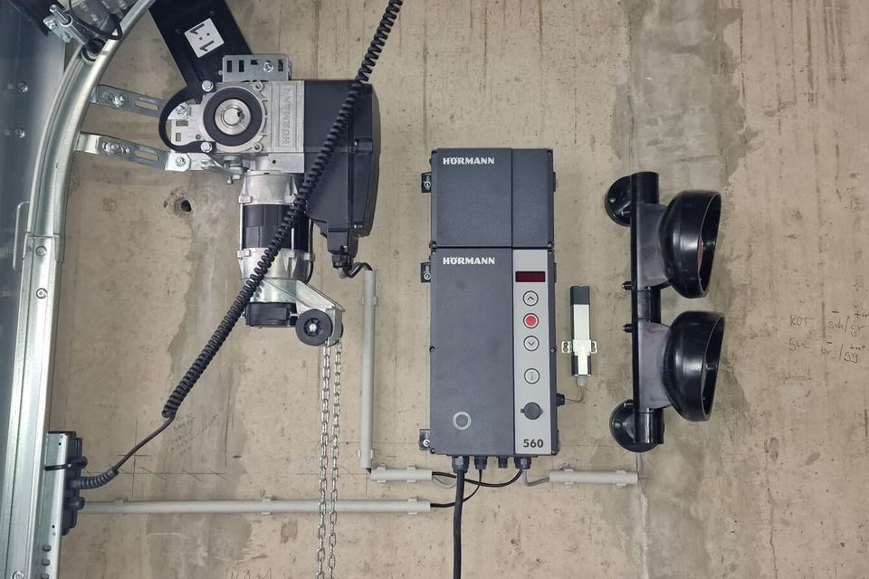 Industrial door operator and Hörmann control unit mounted on the wall beside the door track
