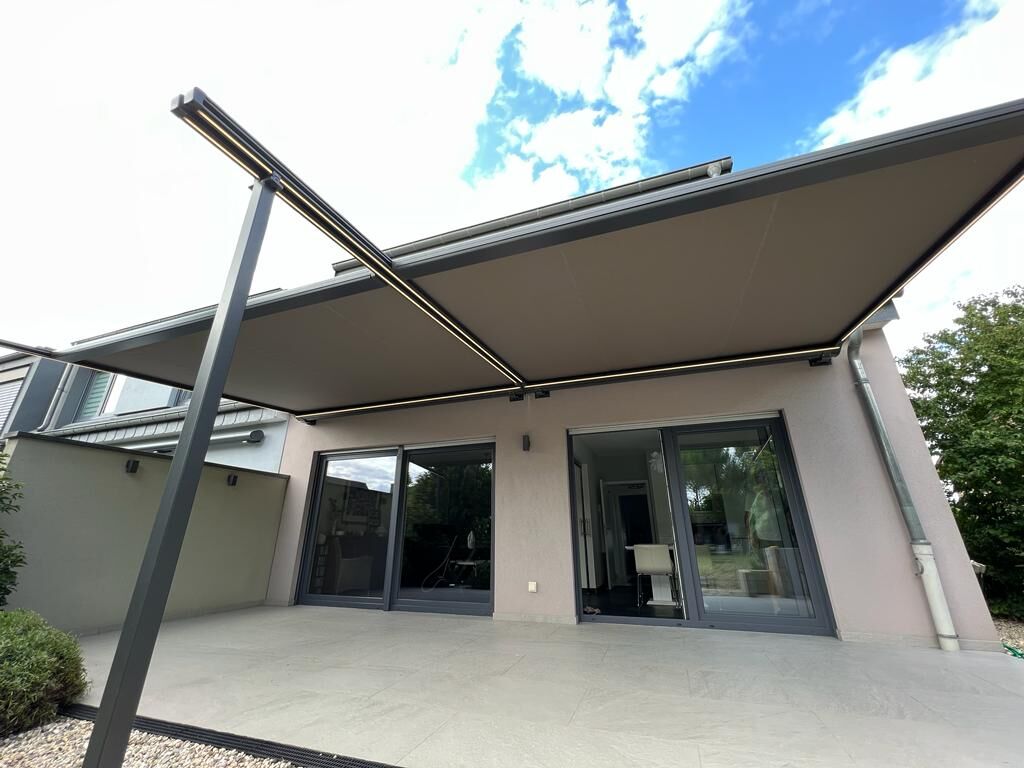 Anthrazit Markise mit Stützen und LED-Armen über Terrasse mit Schiebetüren