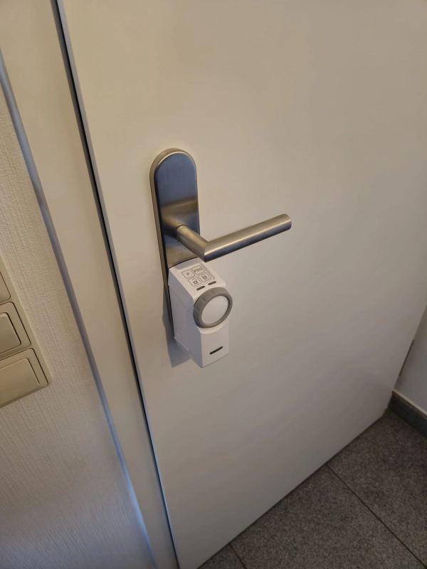 Weißes motorisiertes Smart Lock an der Edelstahl-Drückergarnitur einer weißen Innentür
