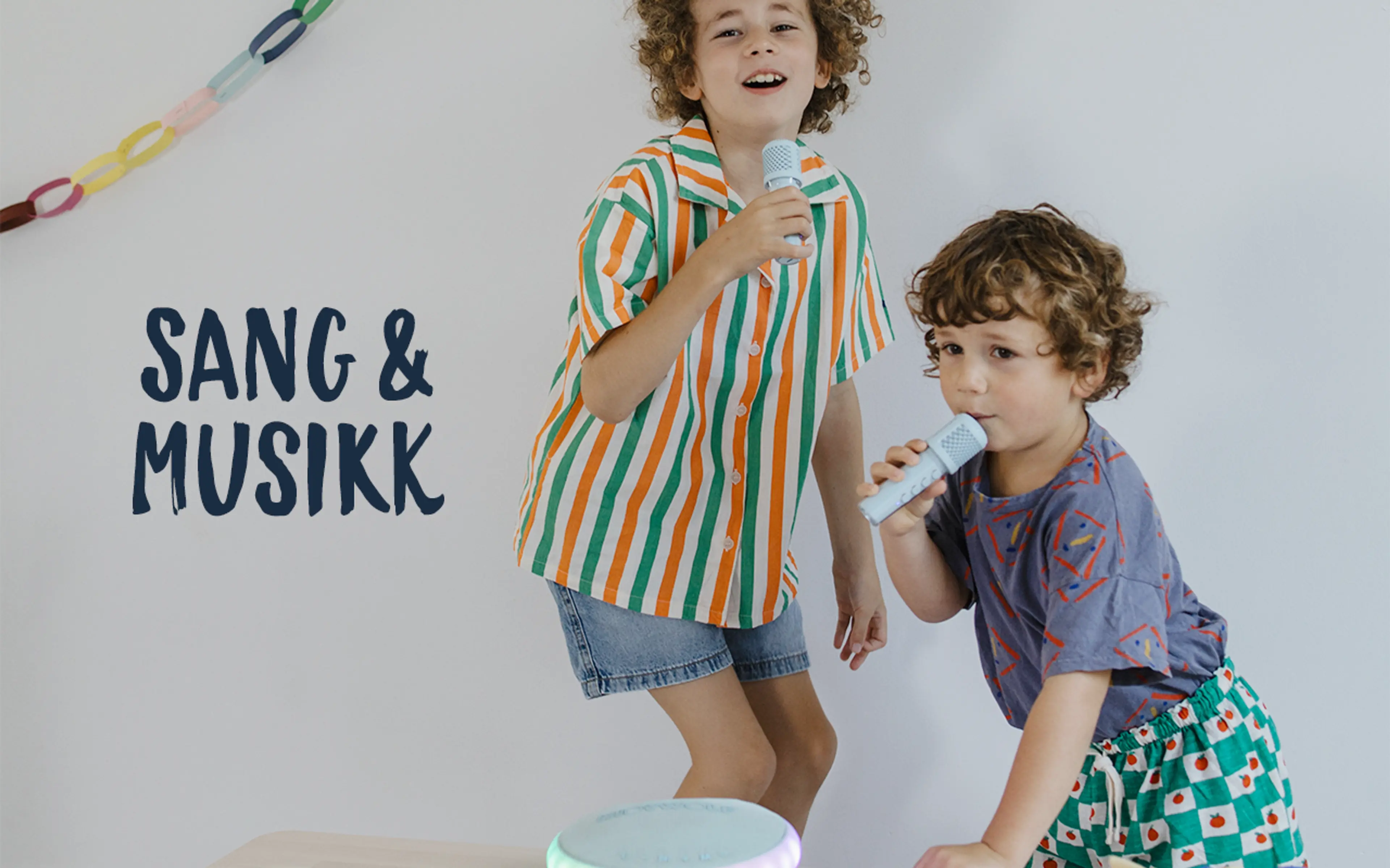 Sang og musikk. Fotografi av to barn som synger duett med Kidykaraoke.