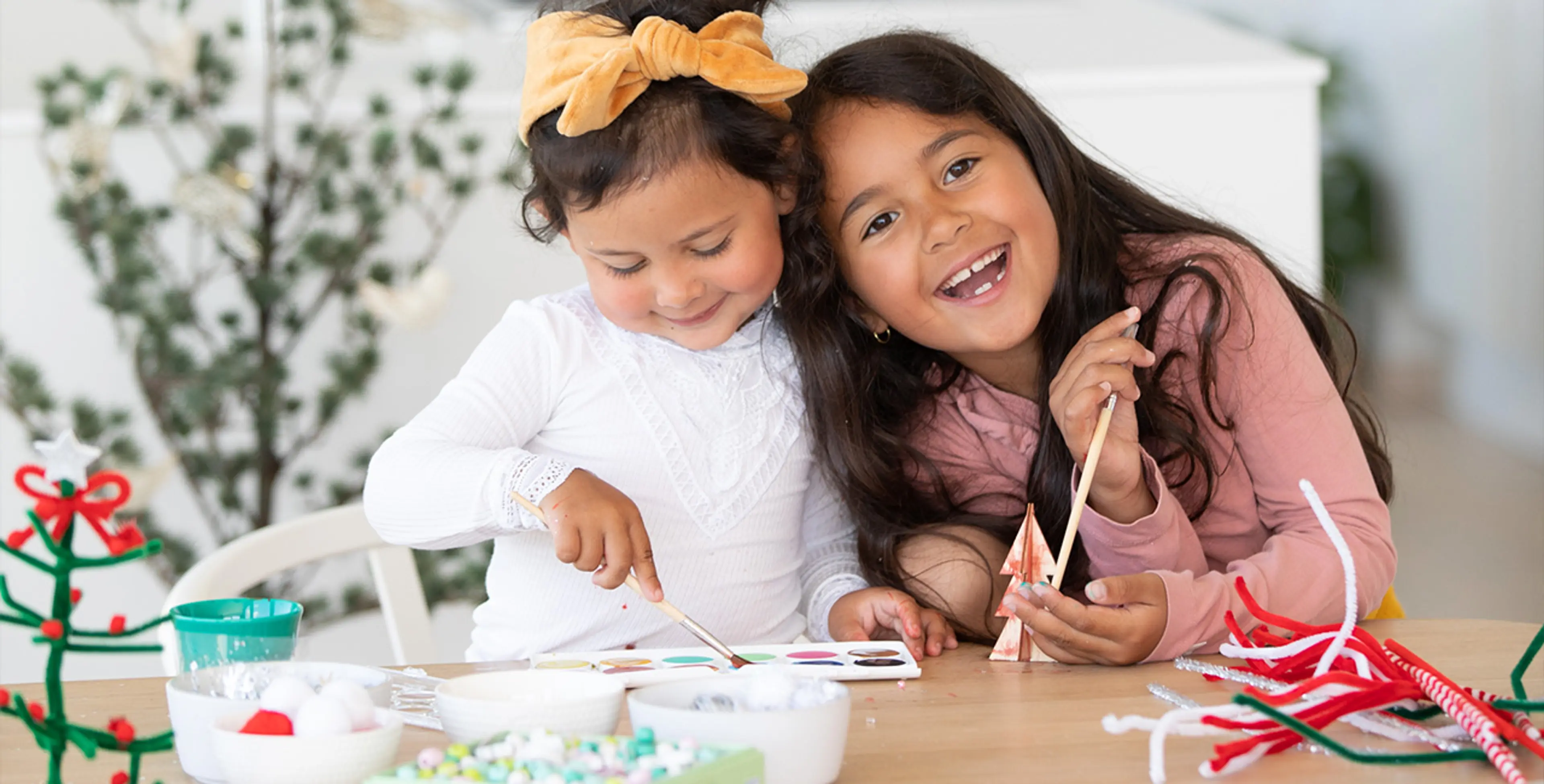 Fotografi av to glade jenter på juleverksted.