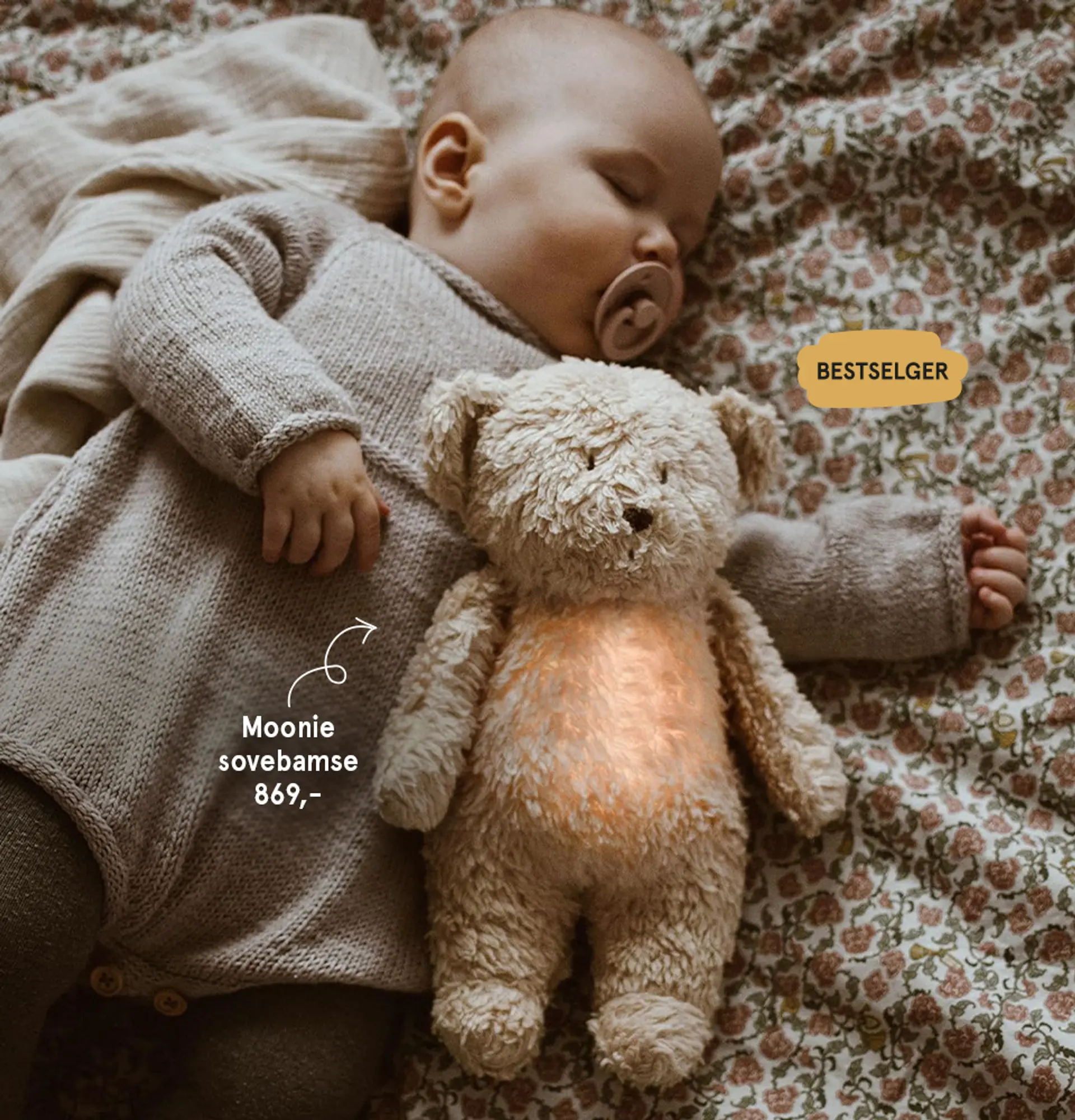 Gavetips til baby: Moonie sovebamse - bestselger. Fotografi av sovende baby med Moonie i armene.