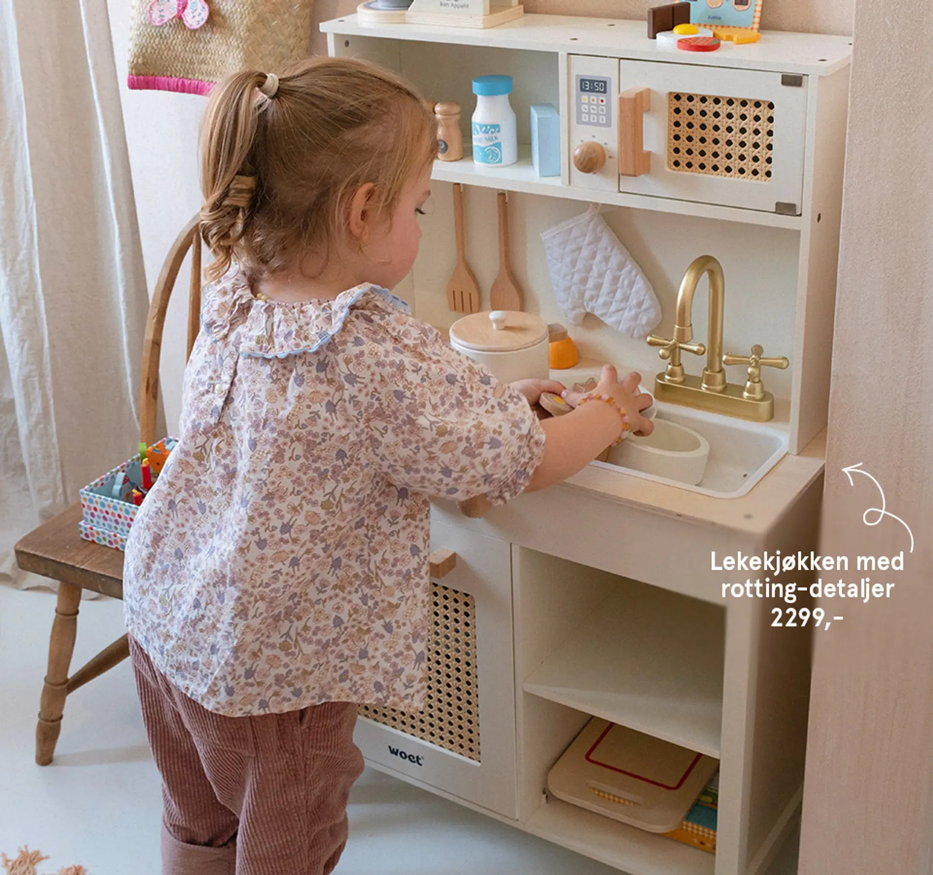 Fotografi av barn som leker med lekekjøkken med rotting-detaljer.