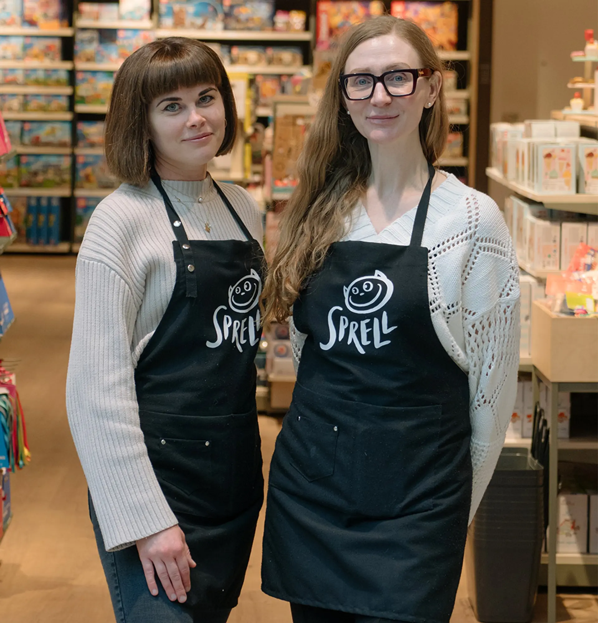 Fotografi av to smilende butikkansatte.