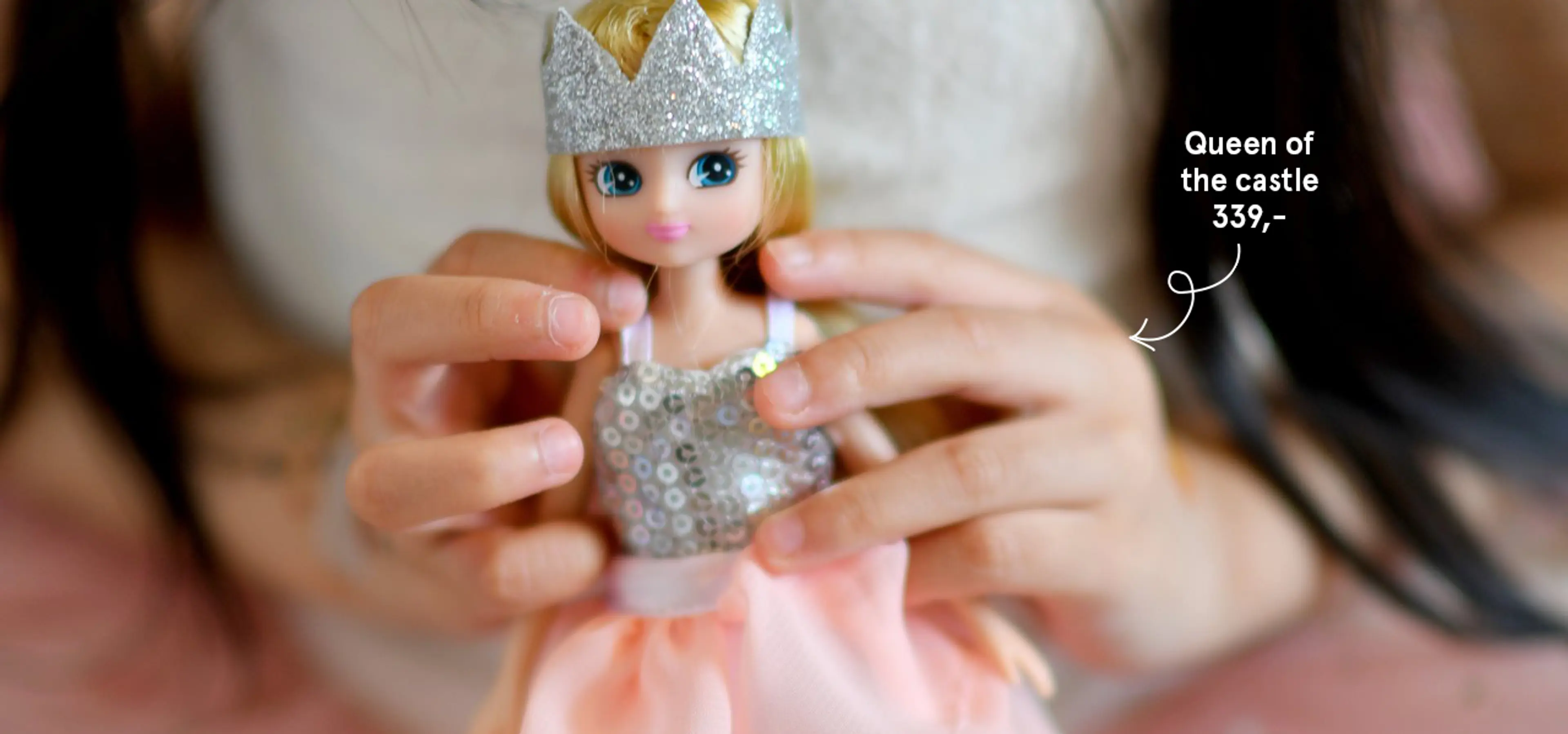 Fotografi av barn som holder en Queen of the castle dukke fra Lottie.